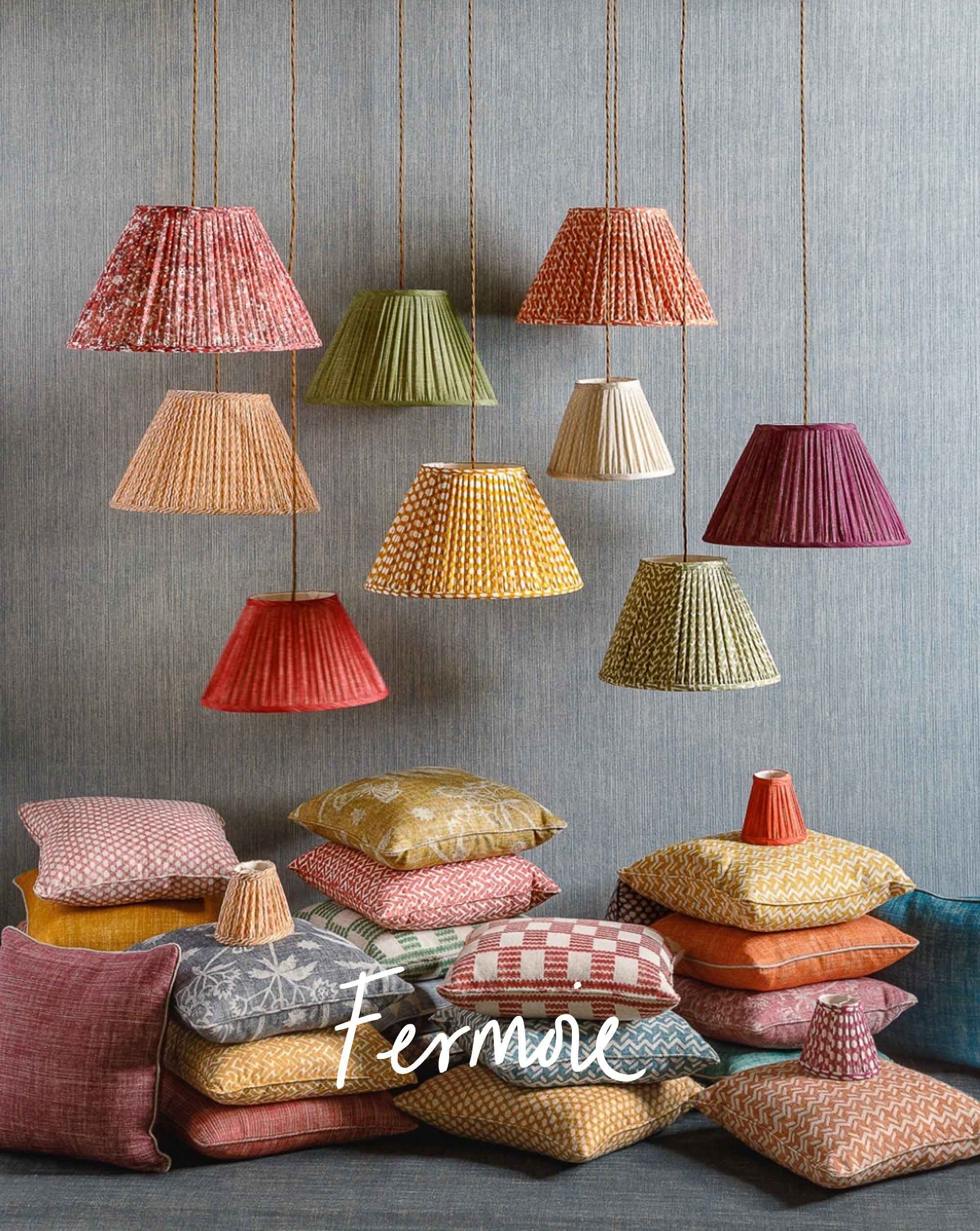 Hanging fermoie lampshades with fermoie cushions stacked on the floor