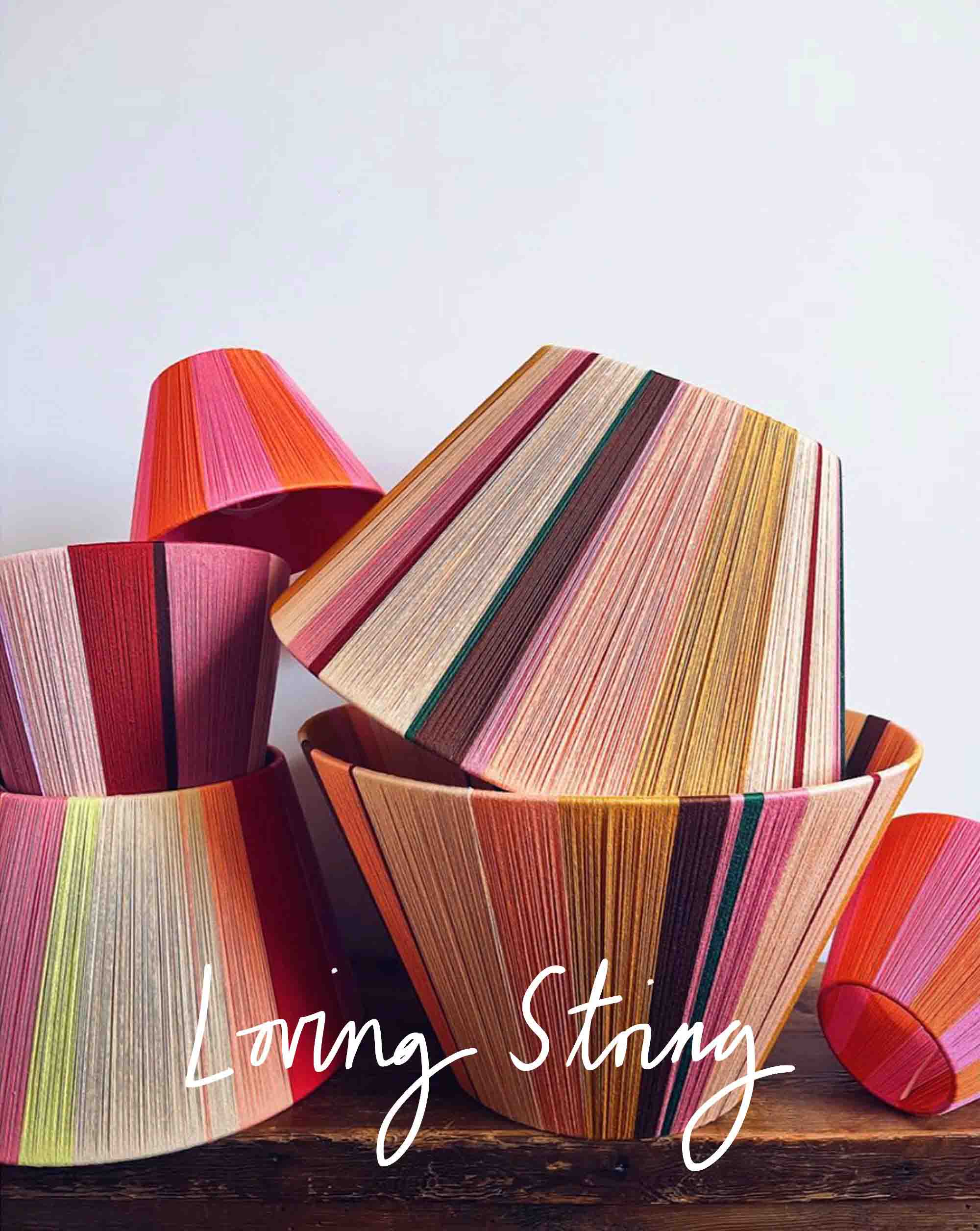 Loving Strings yarn lampshades stacked on angles on table top