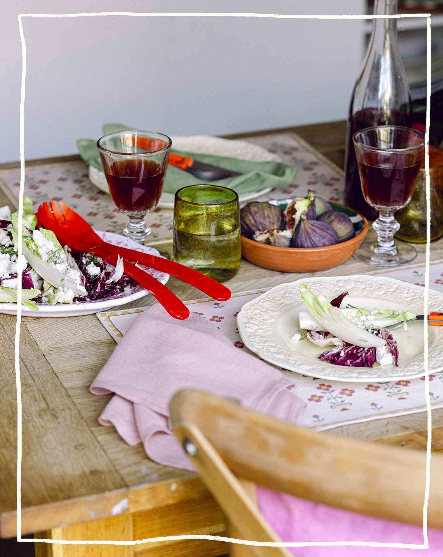 About Us - Dinner table with autumnal salad, wine glasses and figs 